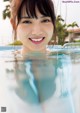 A woman in a swimming pool smiling at the camera.