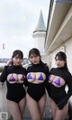 A group of three women standing next to each other on a balcony.