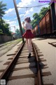 A girl walking down a train track holding a cell phone.