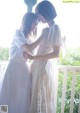 Two young women standing next to each other on a porch.