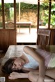 A woman laying on top of a wooden table.